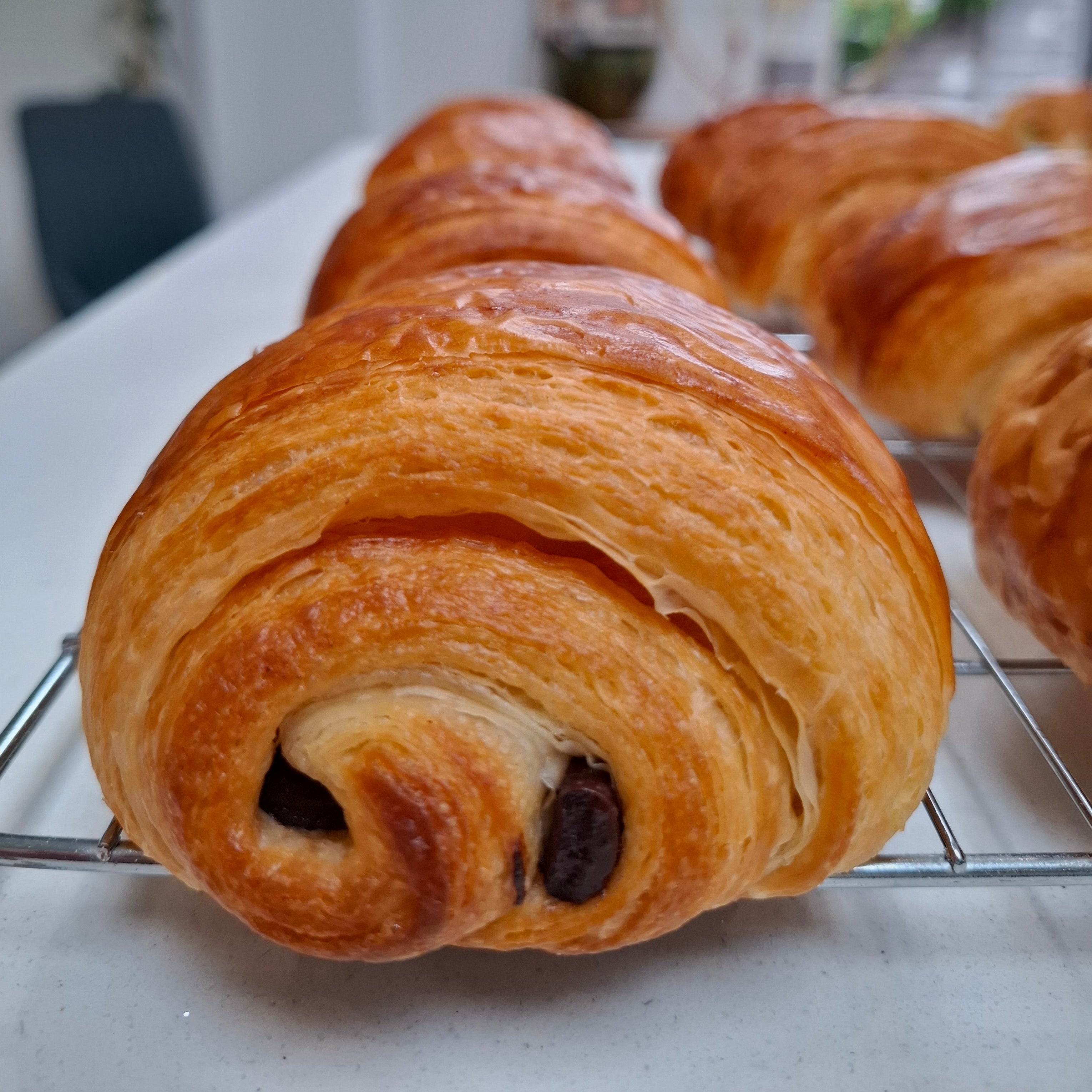 Pastry with a chocolate filling on a cooling rack in a kitchen setting